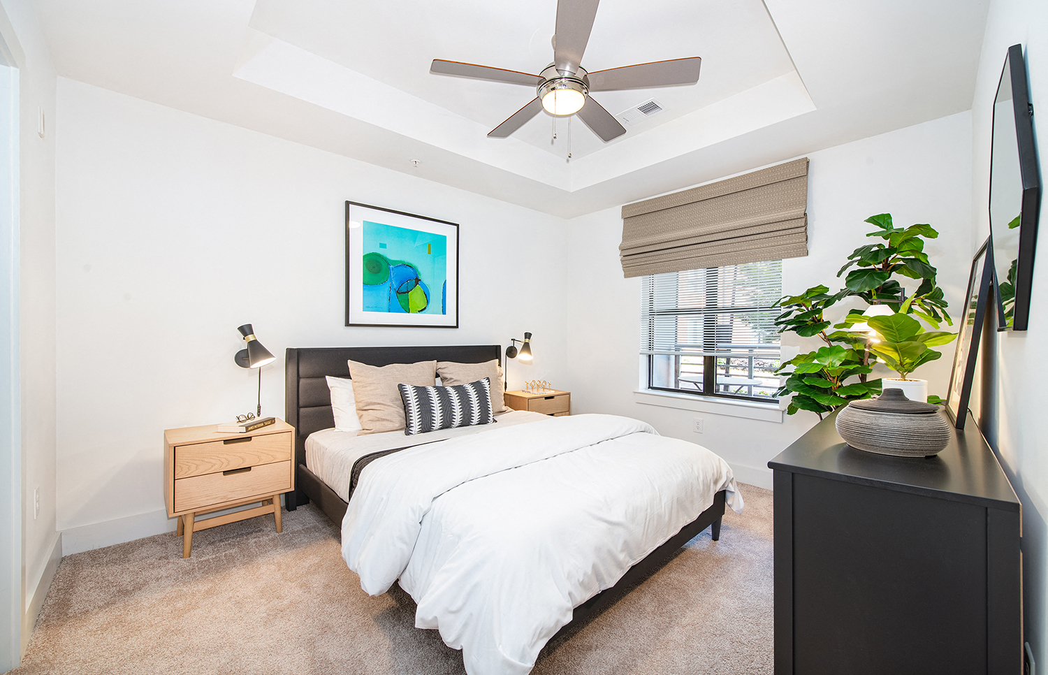 a bedroom with a large bed and a ceiling fan