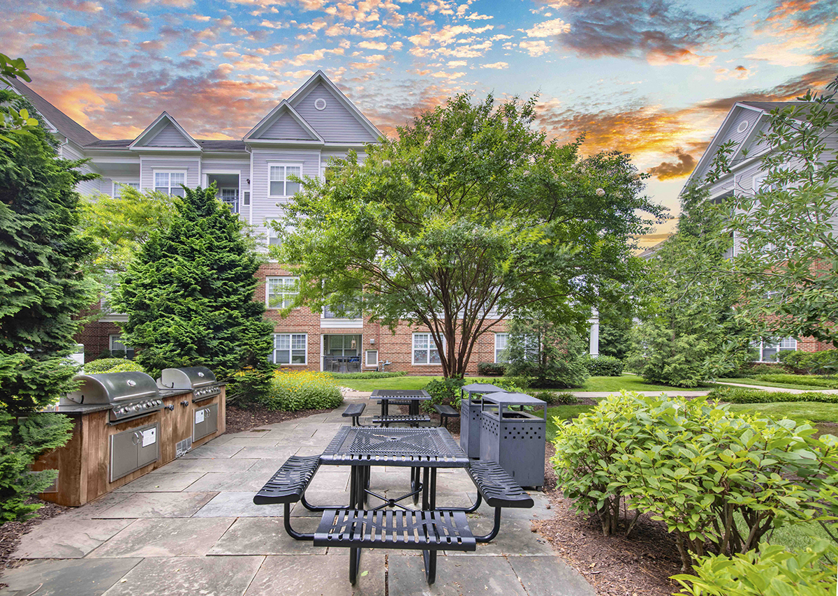 a courtyard with picnic tables and benches in front of a building