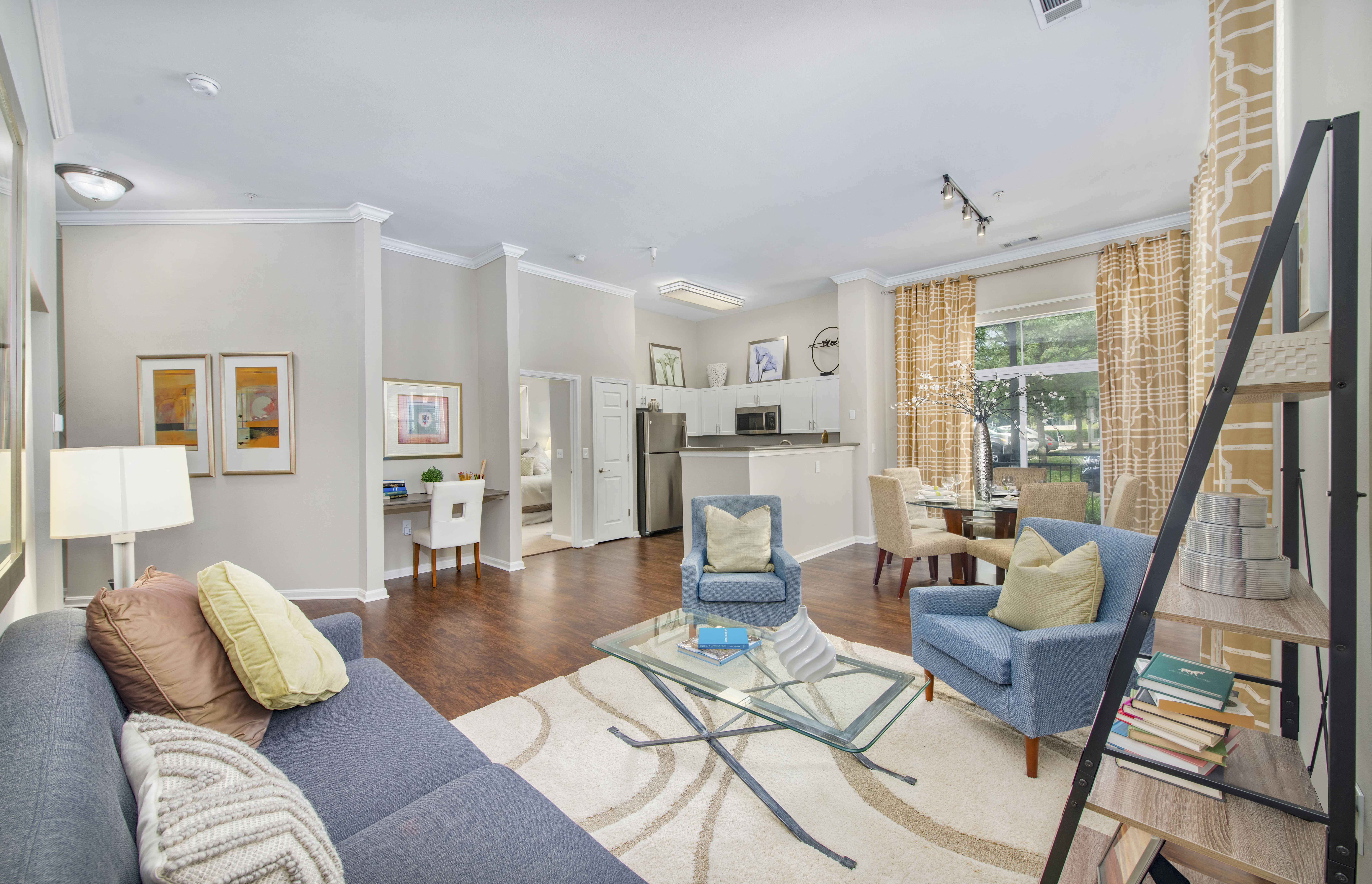 a living room with a blue couch and a glass coffee table