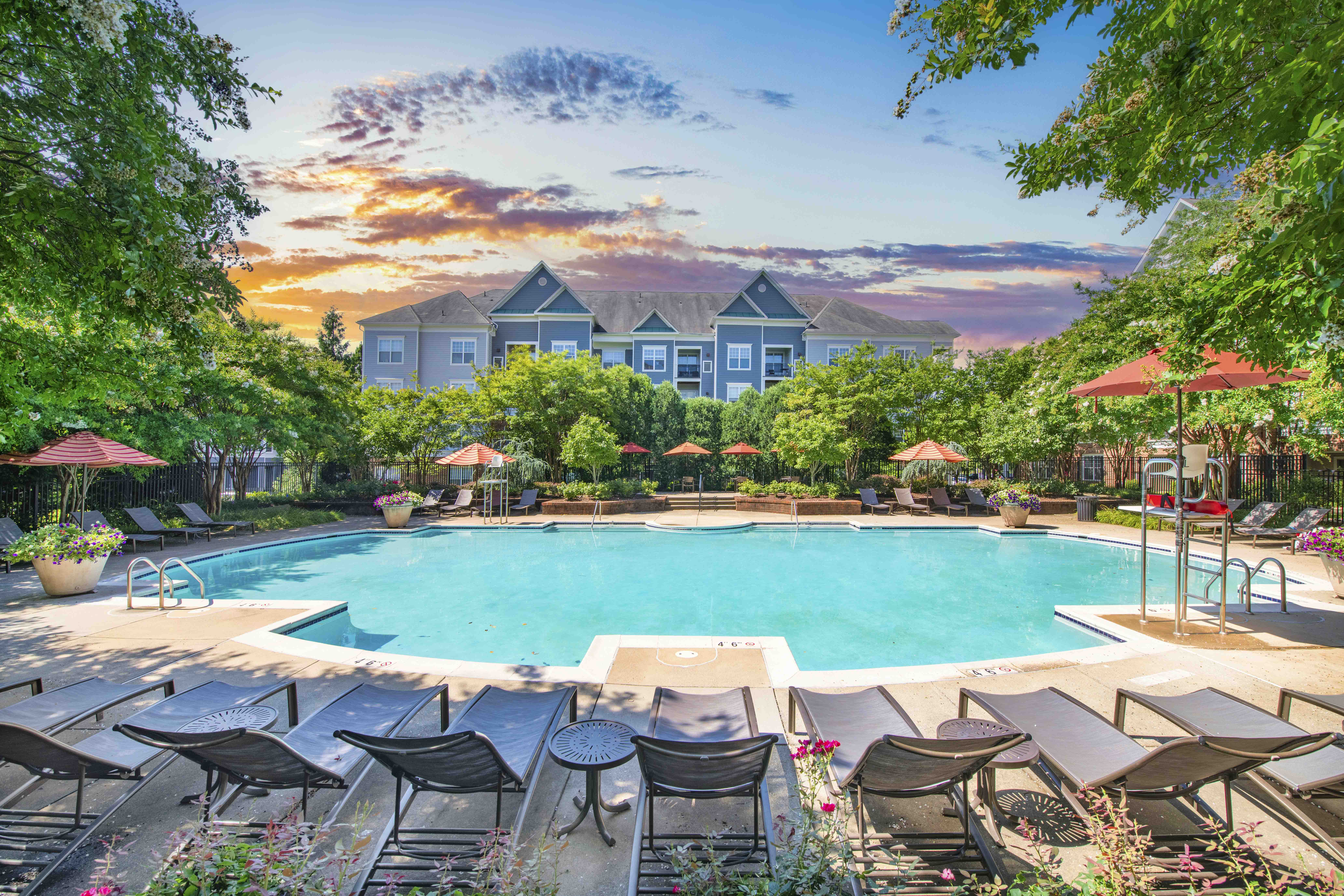 a swimming pool with chairs and umbrellas and a resort style pool
