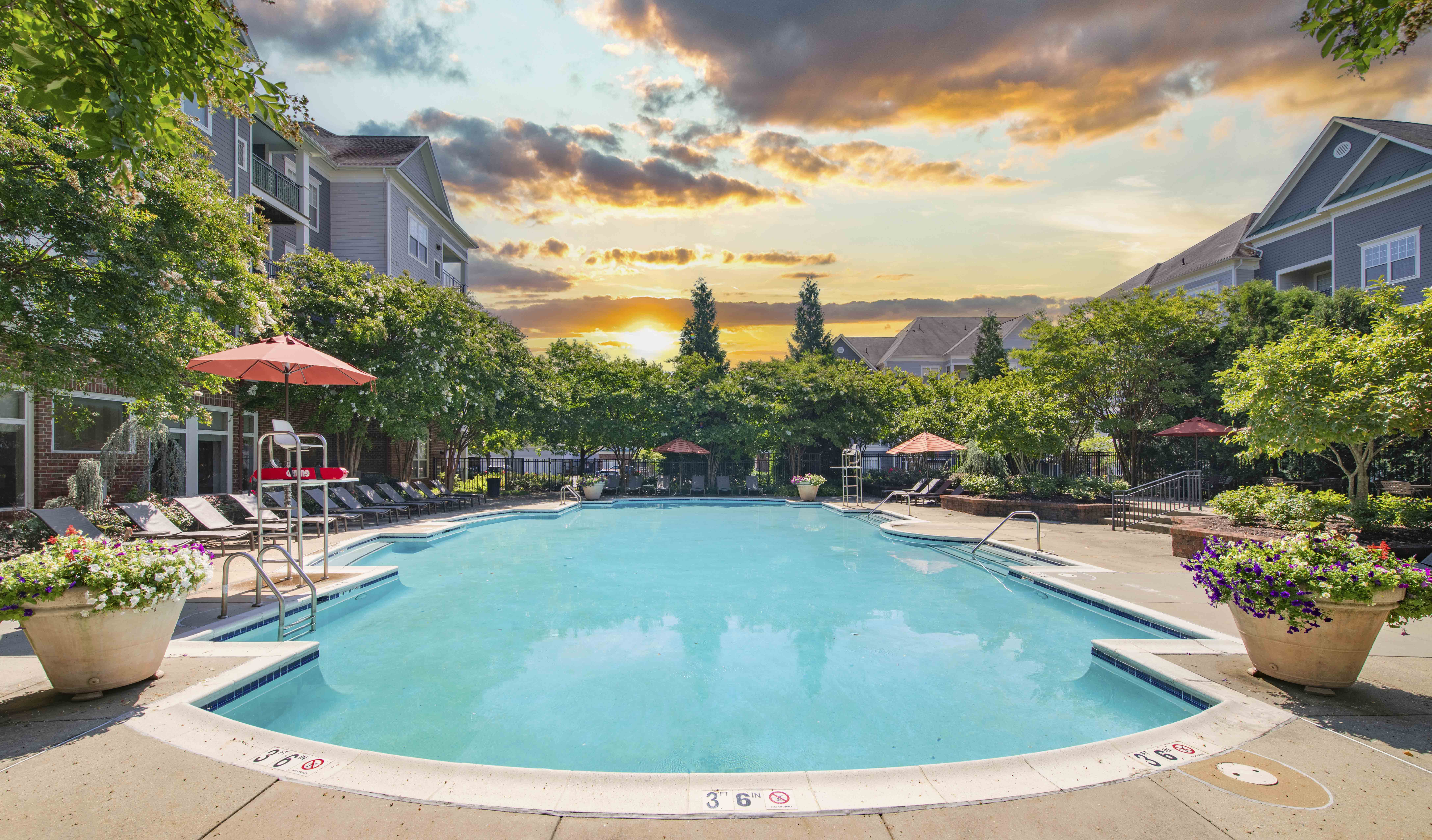 a swimming pool with a sunset in the background
