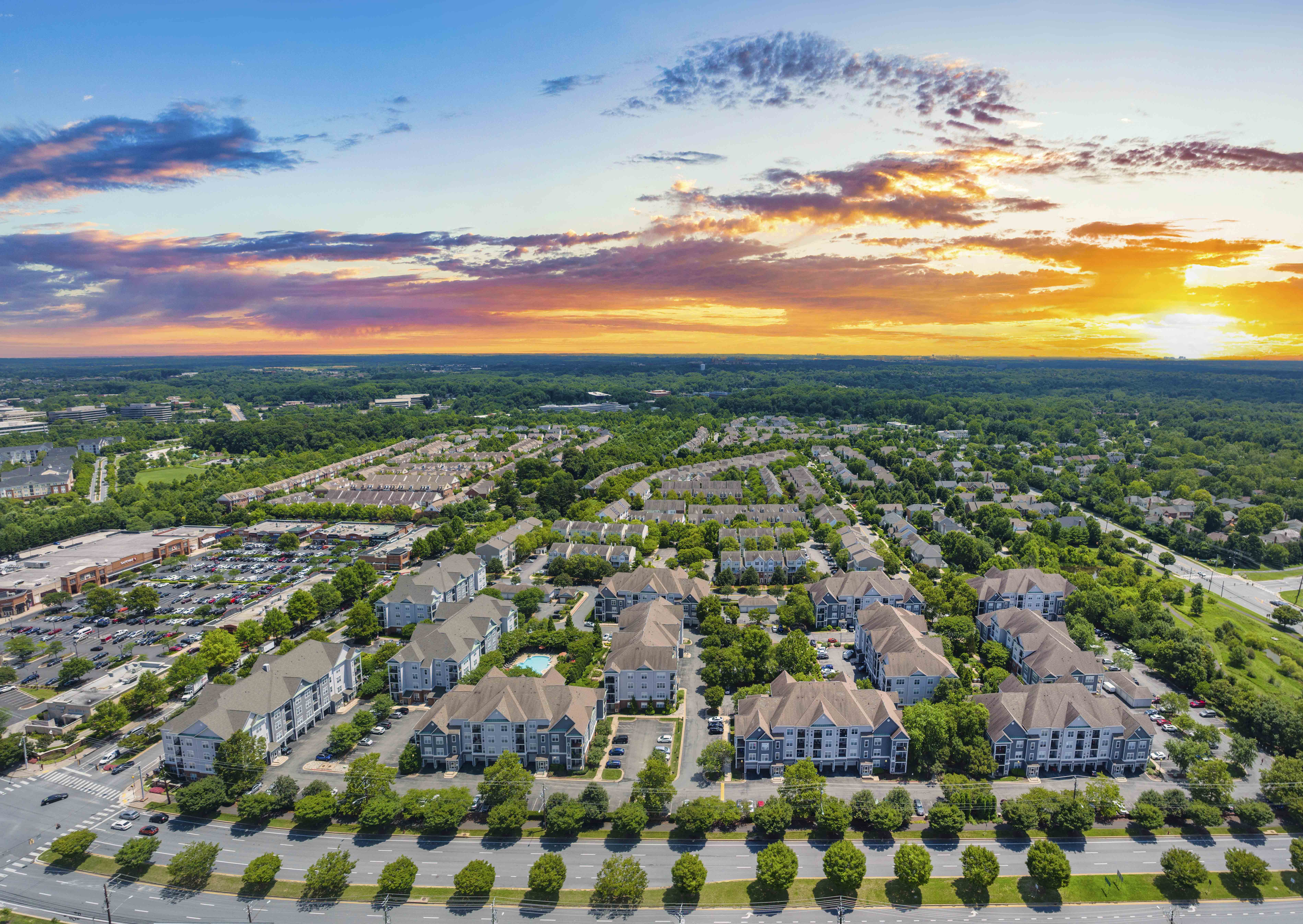an aerial view of a neighborhood with houses and trees at sunset