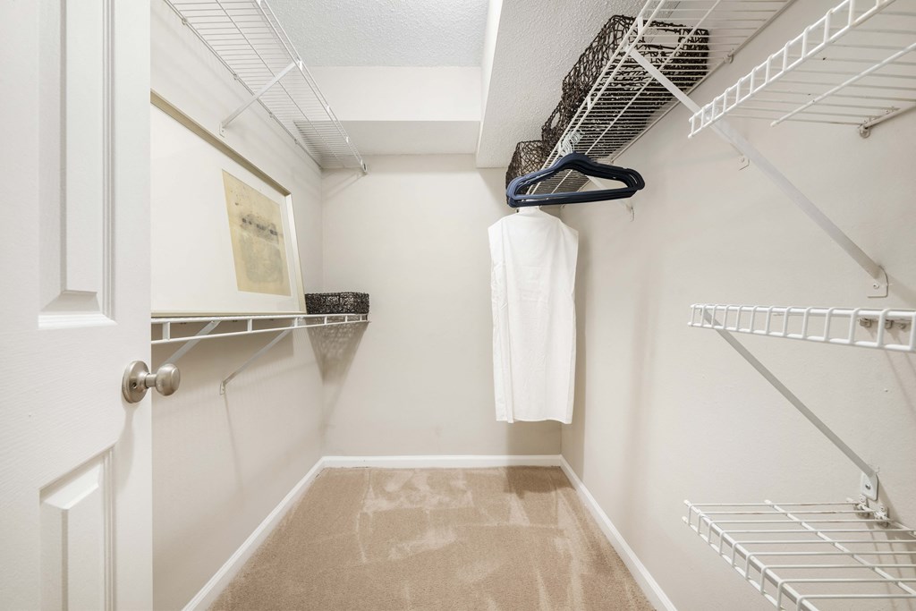 A white closet with a white towel hanging on a rack.
