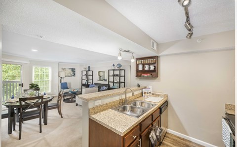A kitchen with a sink and a dining table.