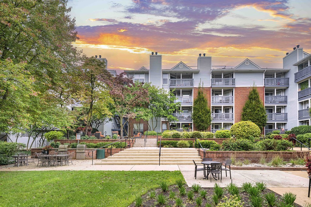A sunset view of a residential area with apartment buildings and a park.