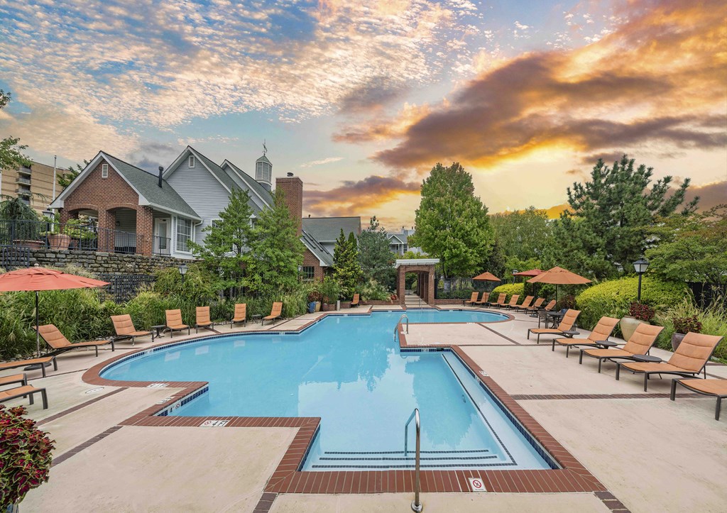 A large swimming pool surrounded by lounge chairs and umbrellas.