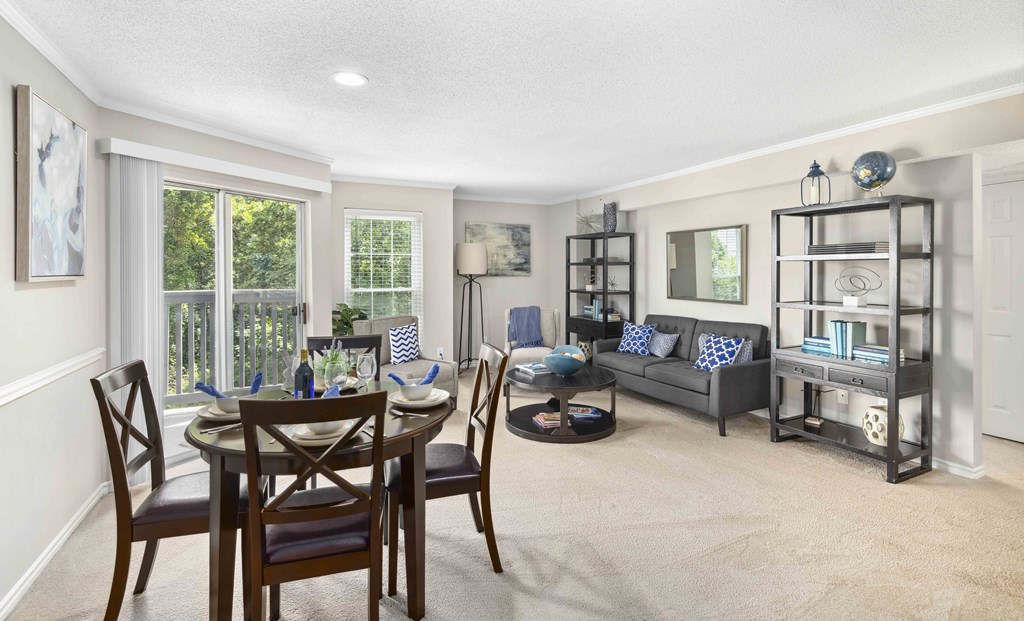 A dining room with a table set for four and a couch with a blue cushion.
