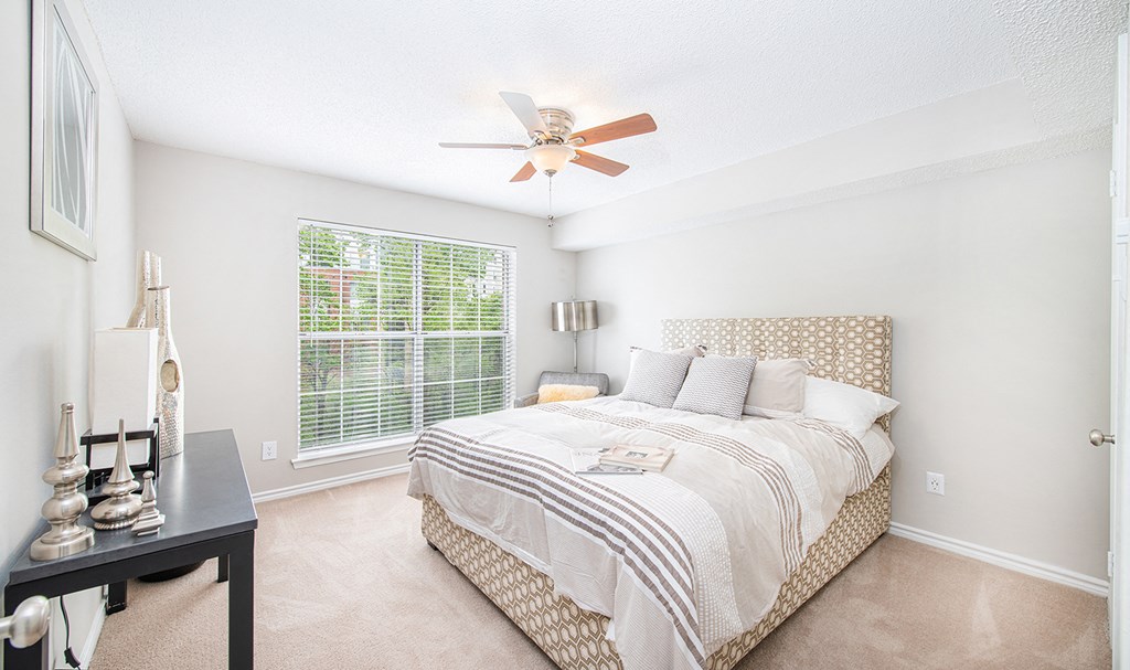 a bedroom with a large bed and a ceiling fan