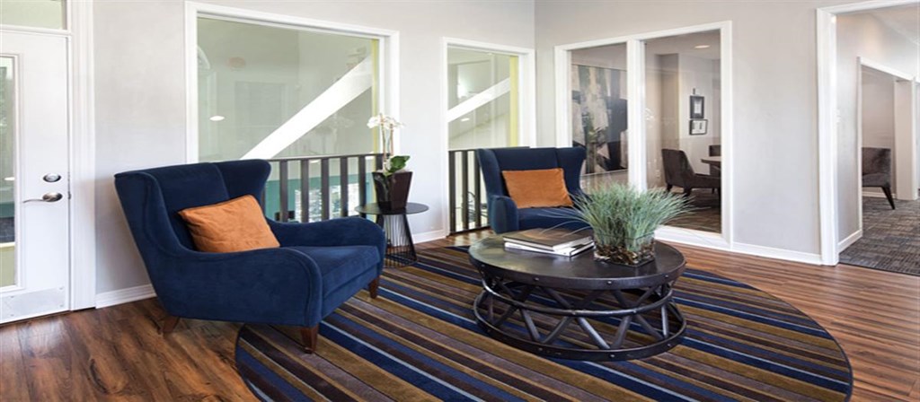 a living room with two blue chairs and a table