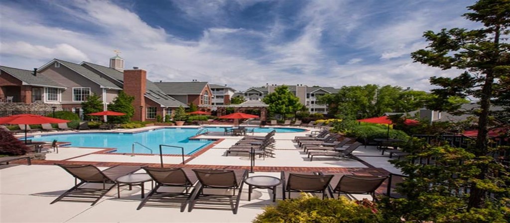 a large pool with chairs and umbrellas at the resort