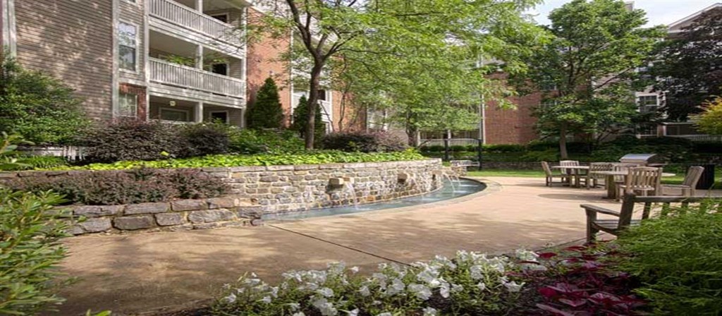 a courtyard with tables and chairs in front of a building