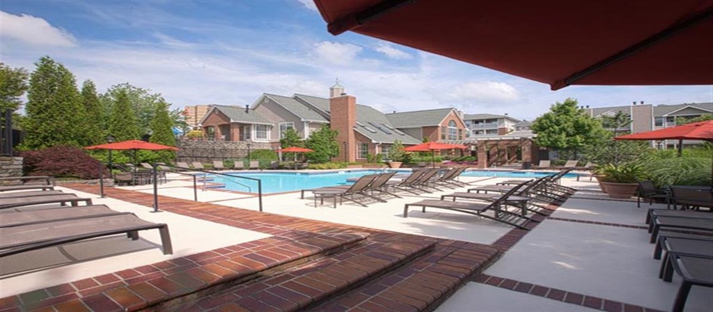 a swimming pool with lounge chairs and umbrellas