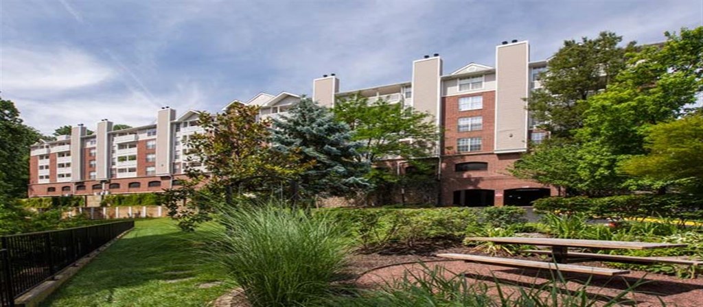 a park with benches in front of an apartment building