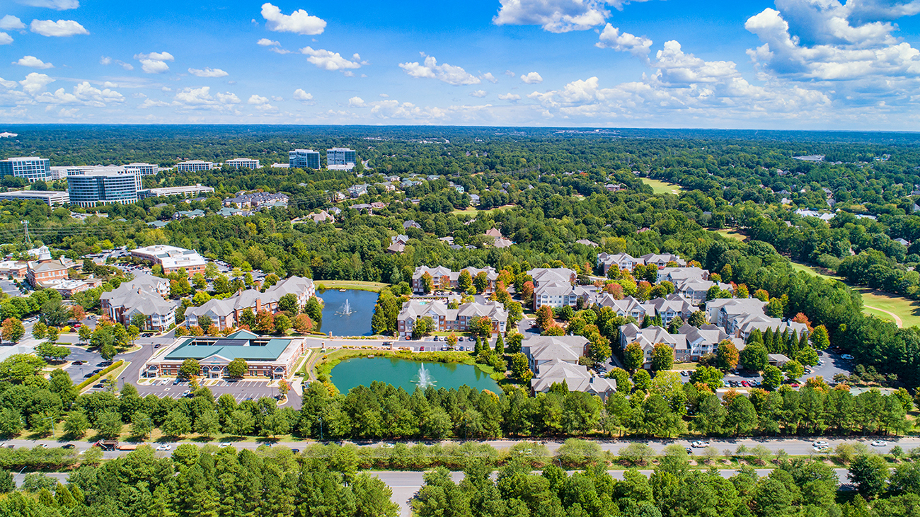 a aerial view of a city with a pond and buildings