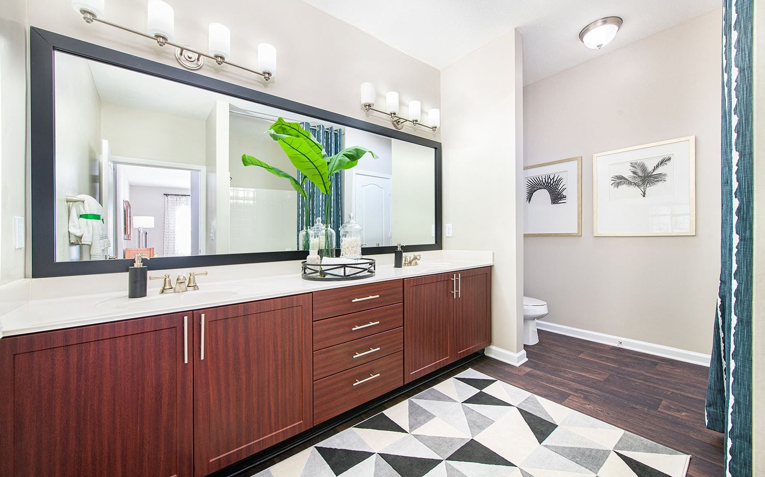 a bathroom with a large mirror and wooden cabinets