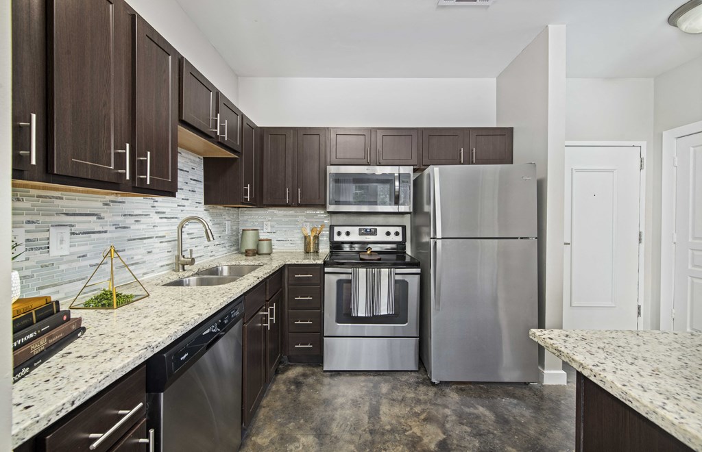 a kitchen with stainless steel appliances and marble counter tops