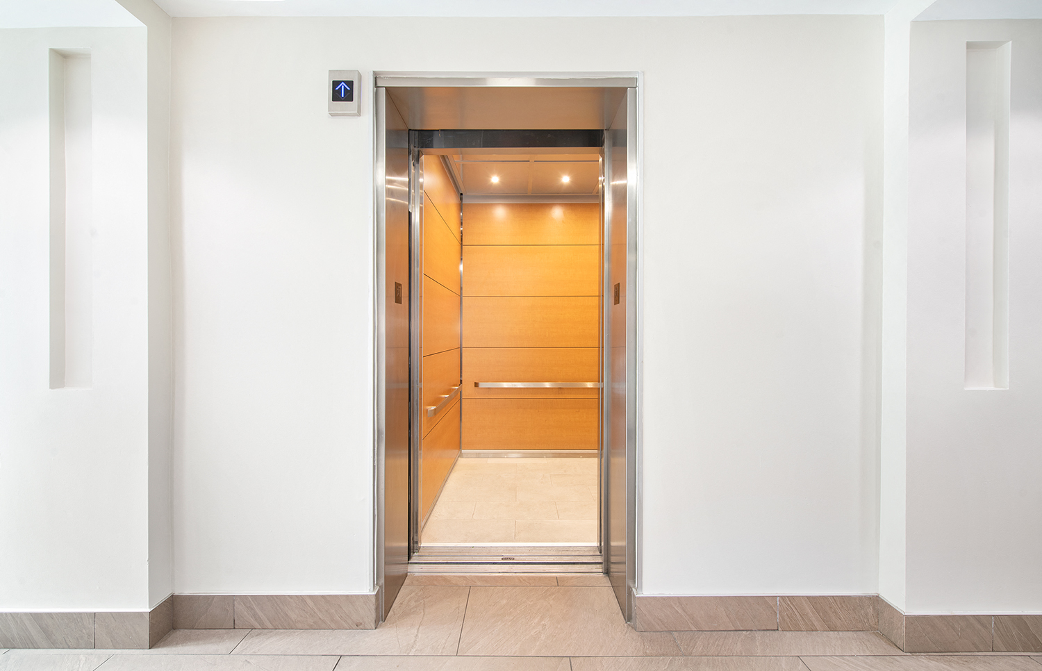 a white elevator with a wooden door in a building