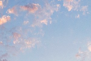 an apartment building with a blue and orange sky above it