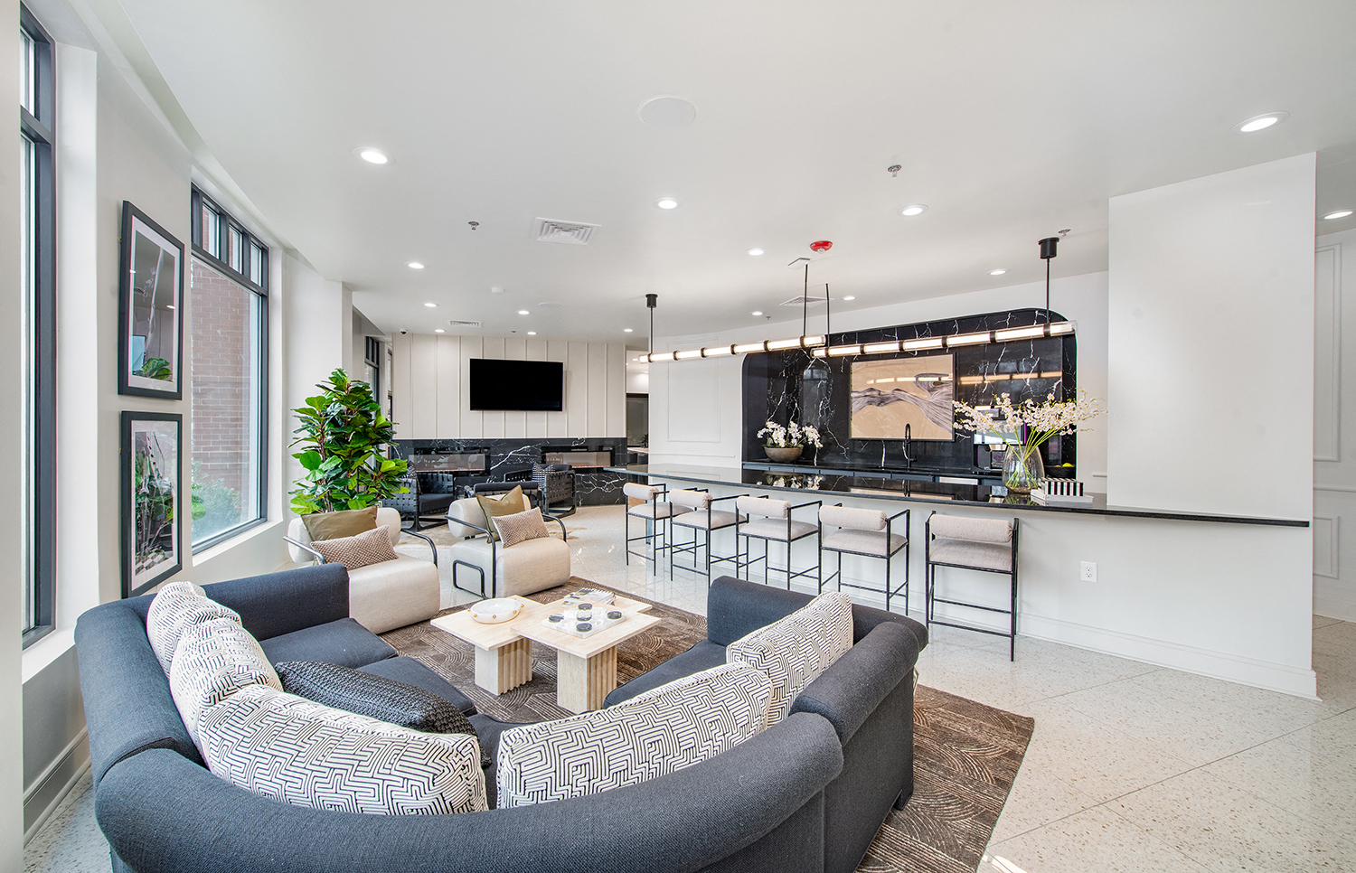 a living room with couches and chairs and a kitchen with a bar