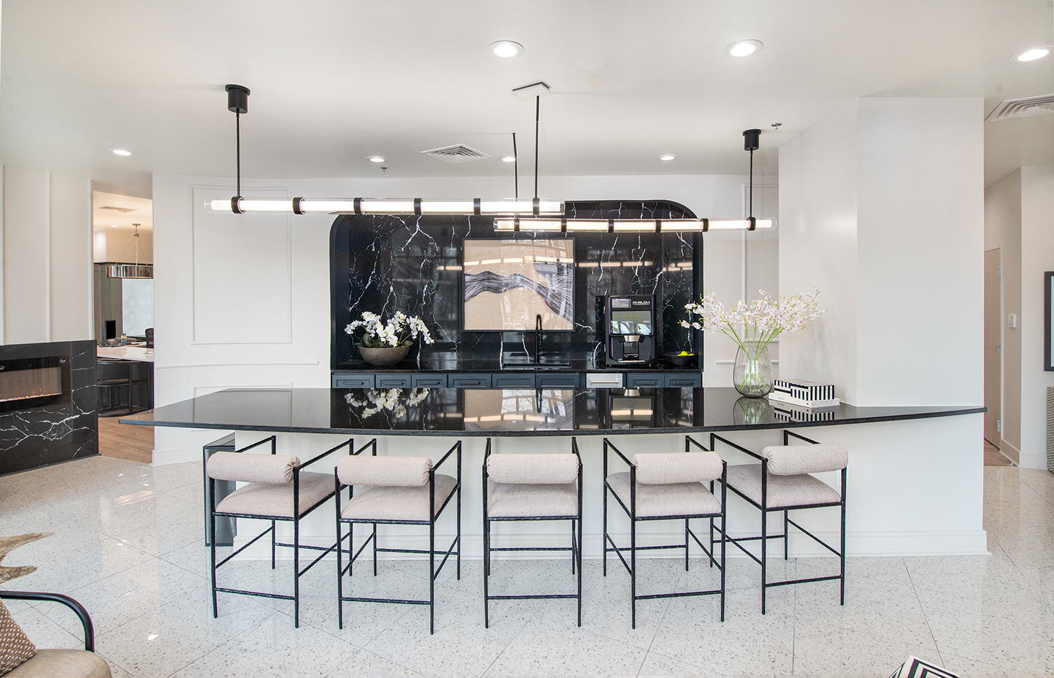 the kitchen has a large island with black quartz countertops and a large black fireplace