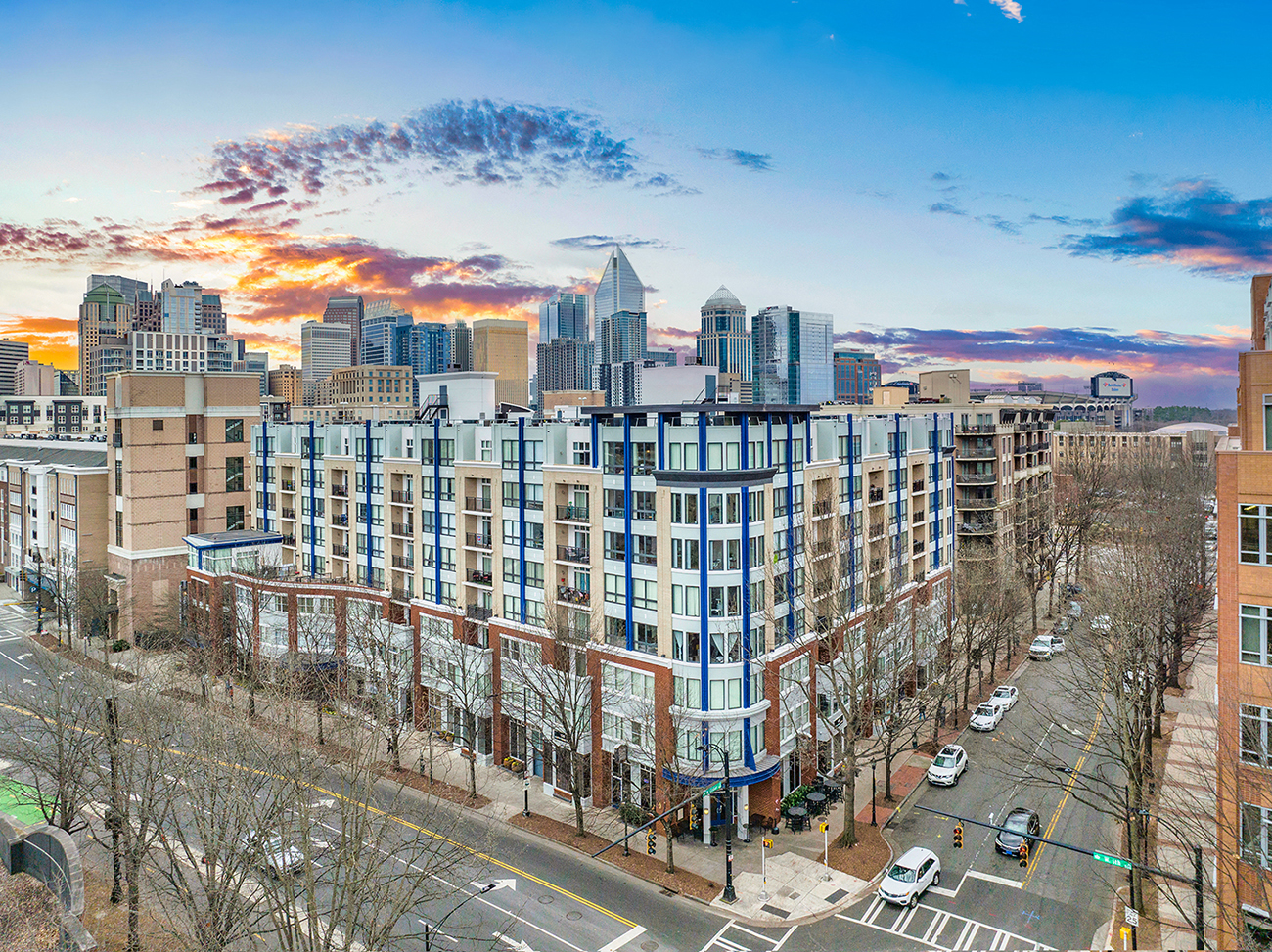 an aerial view of a building with a city skyline in the background
