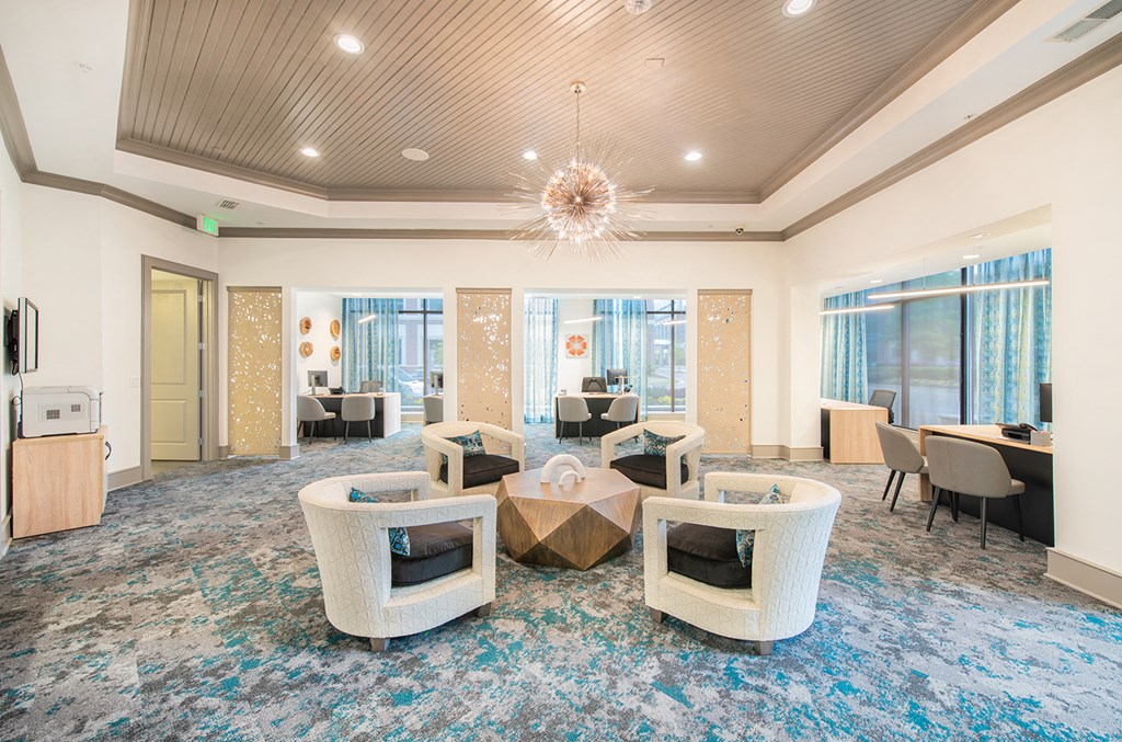a lounge area with chairs and a table and a chandelier