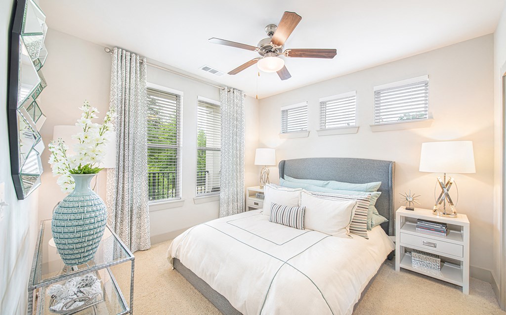 a bedroom with a large bed and a ceiling fan