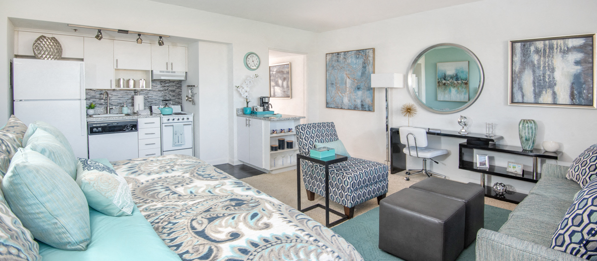 a living room with a couch and a kitchen with a sink