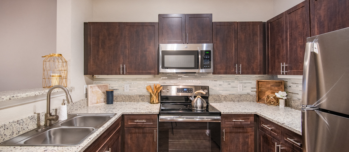 an updated kitchen with stainless steel appliances and wooden cabinets