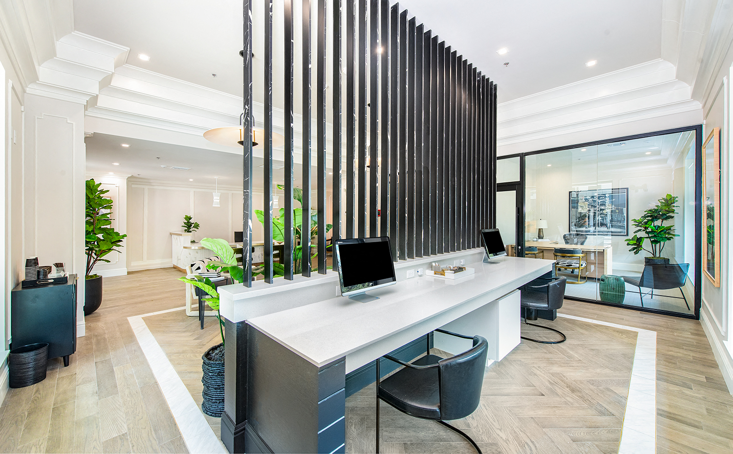 a large office with a long desk with two computers on it