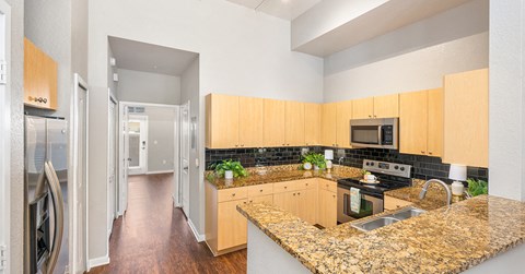 a kitchen with granite counter tops and wooden cabinets