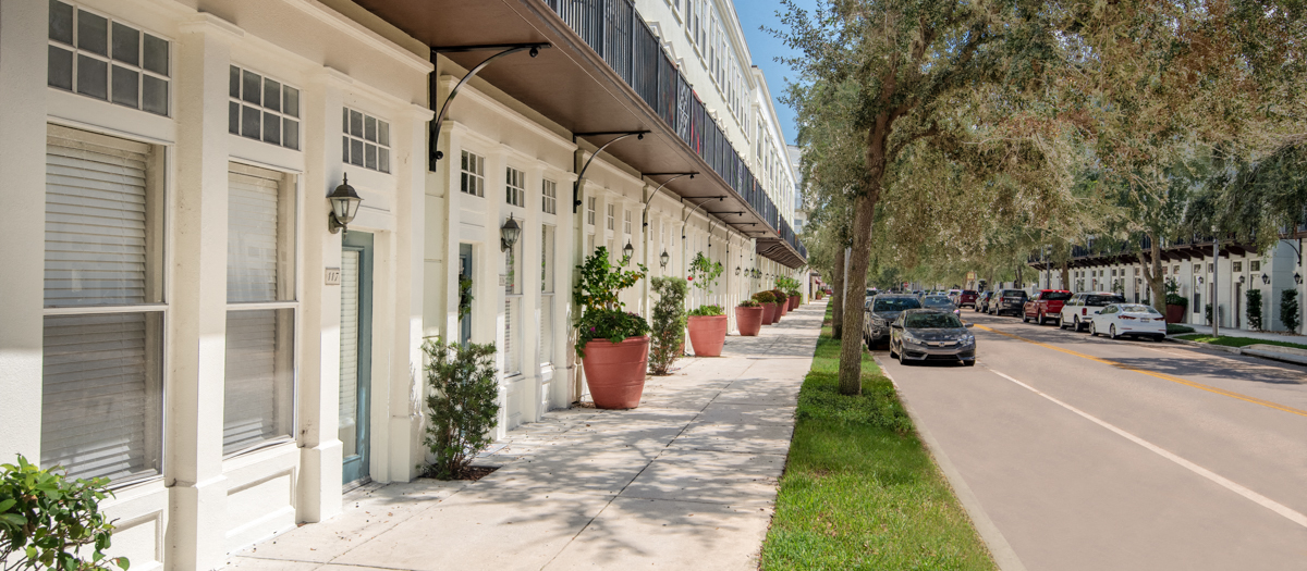 a row of buildings on the side of a street with cars parked