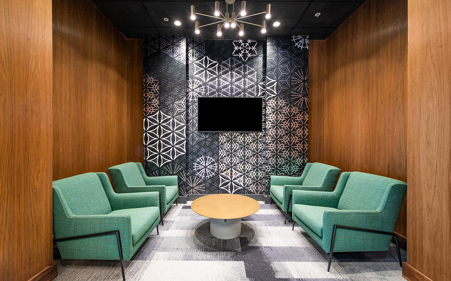 a lobby with green chairs and a table and a television