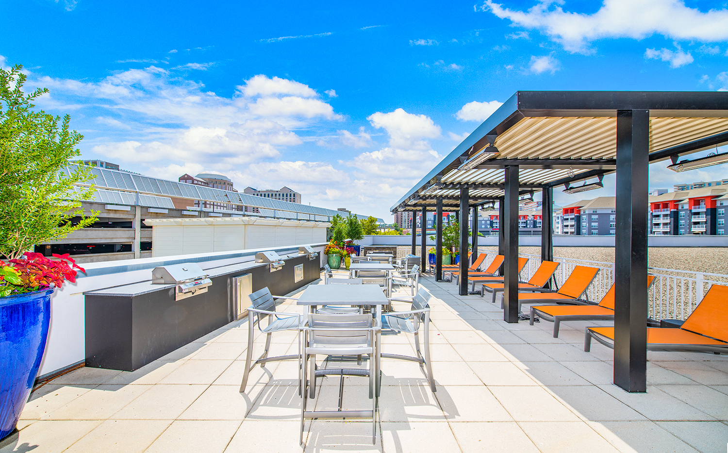 a rooftop patio with tables and chairs and a bar