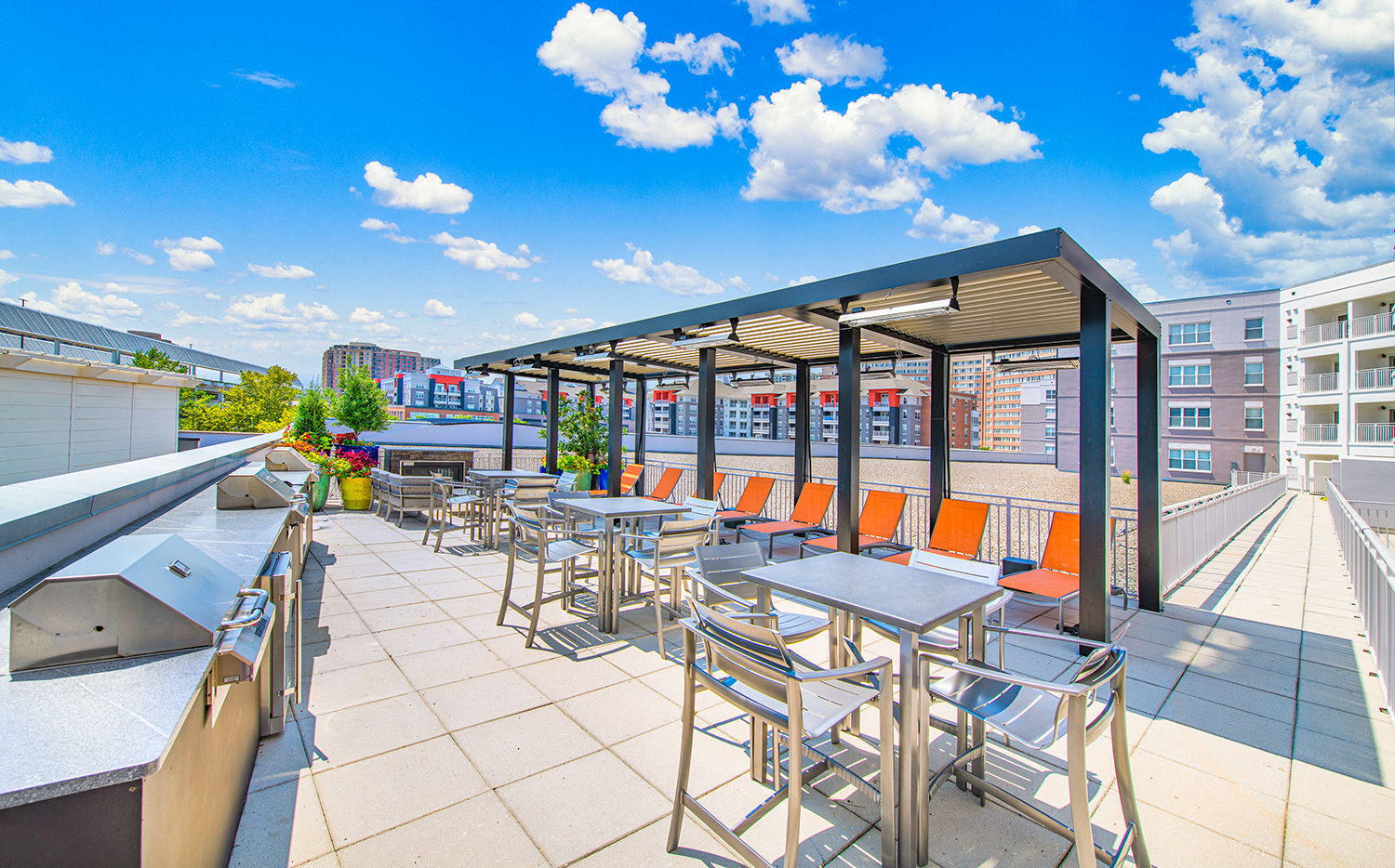 a rooftop patio with tables and chairs and a pergola