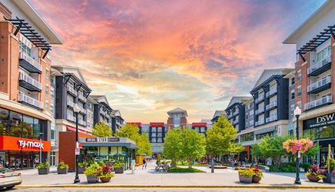 a rendering of a city street with buildings and a sunset in the sky