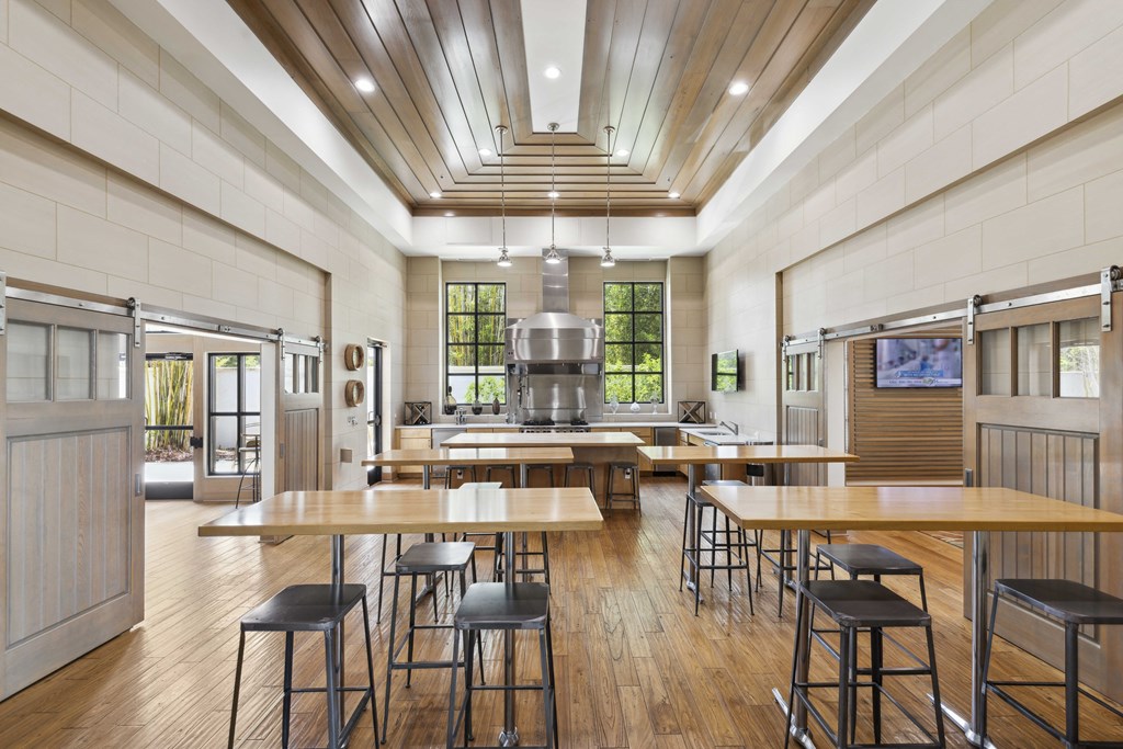 a large kitchen with wood floors and tables and chairs