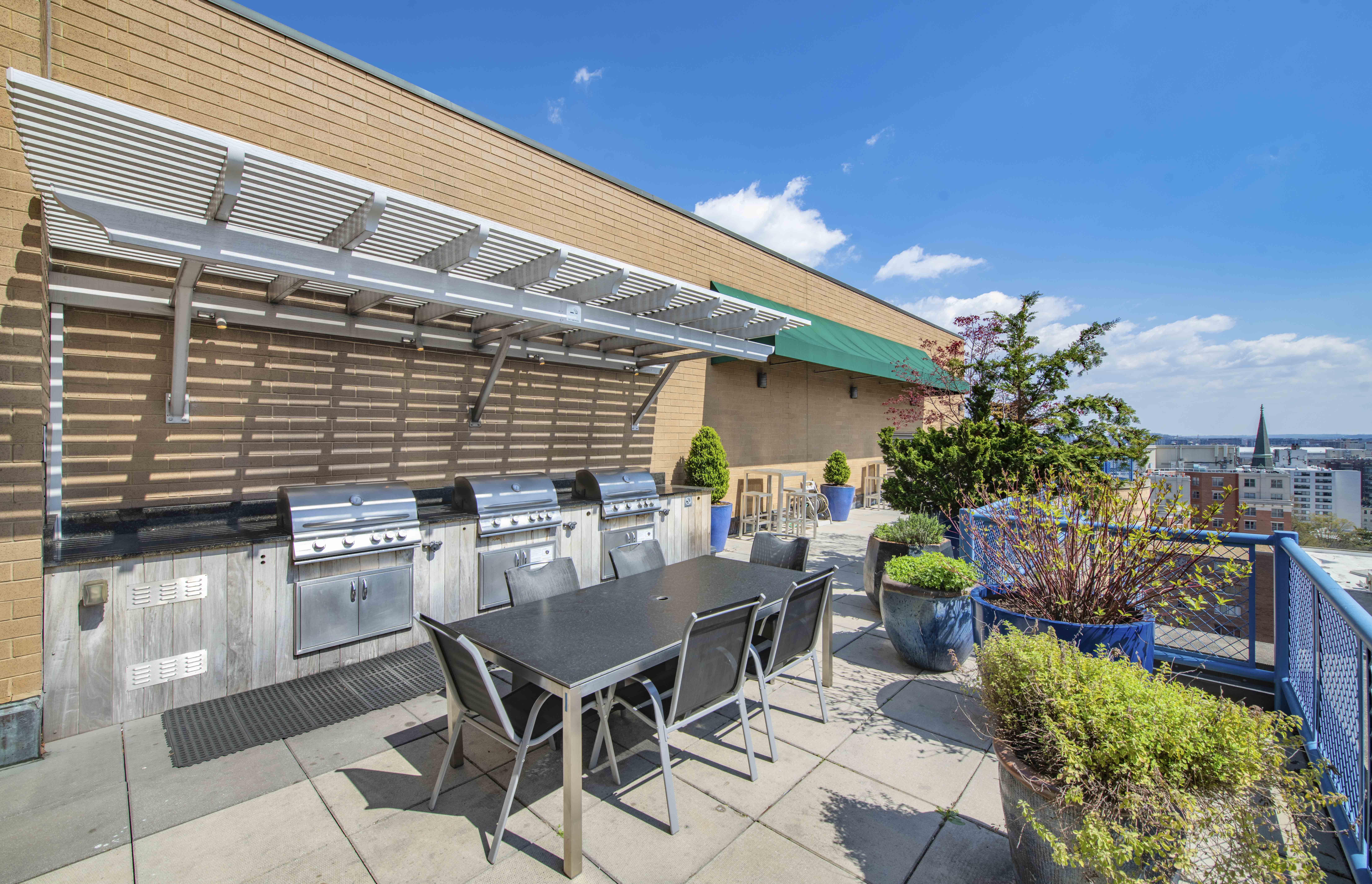 a patio with a table and chairs and a barbecue grill