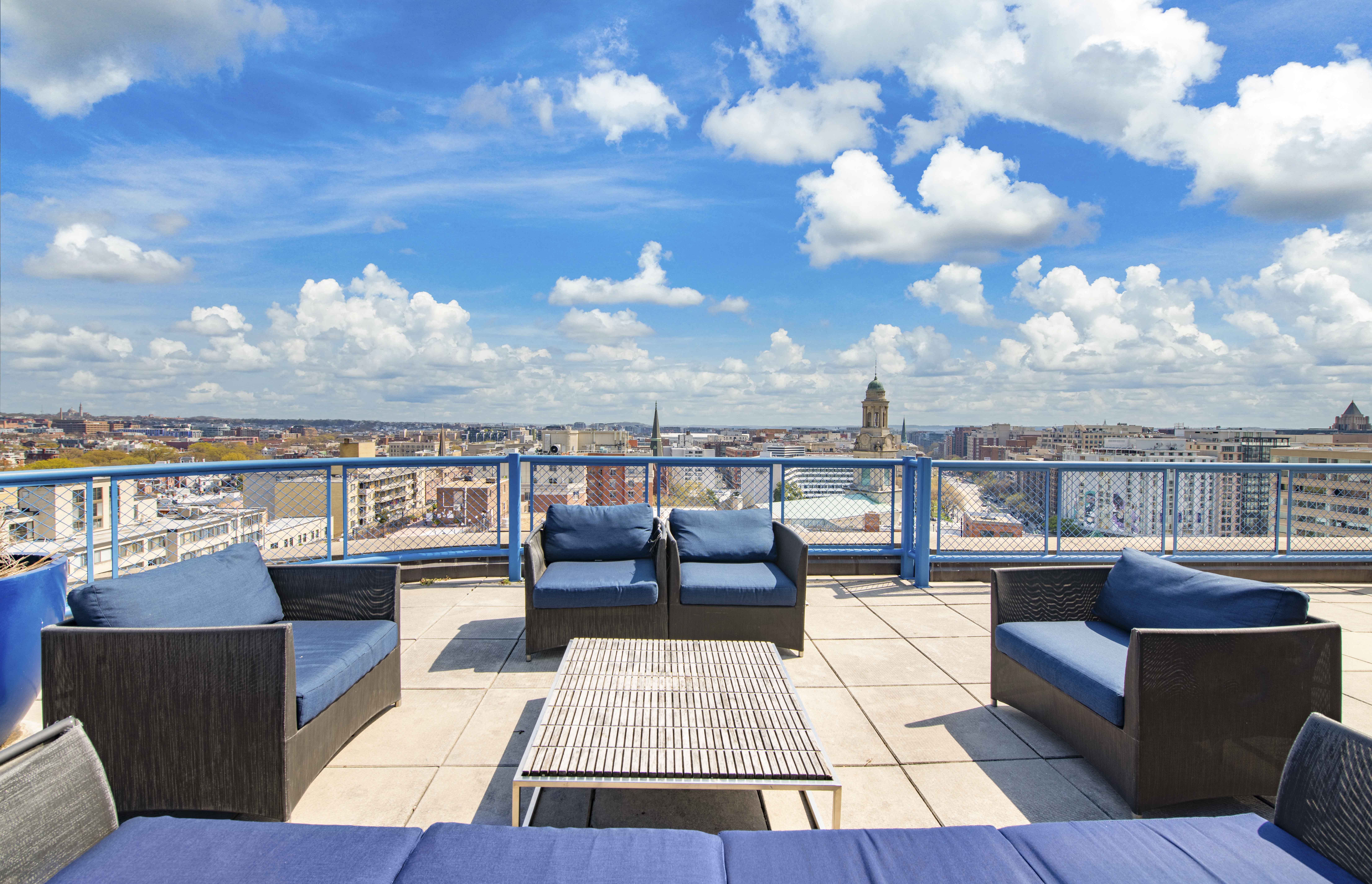 a view of the city from a balcony with couches and a table