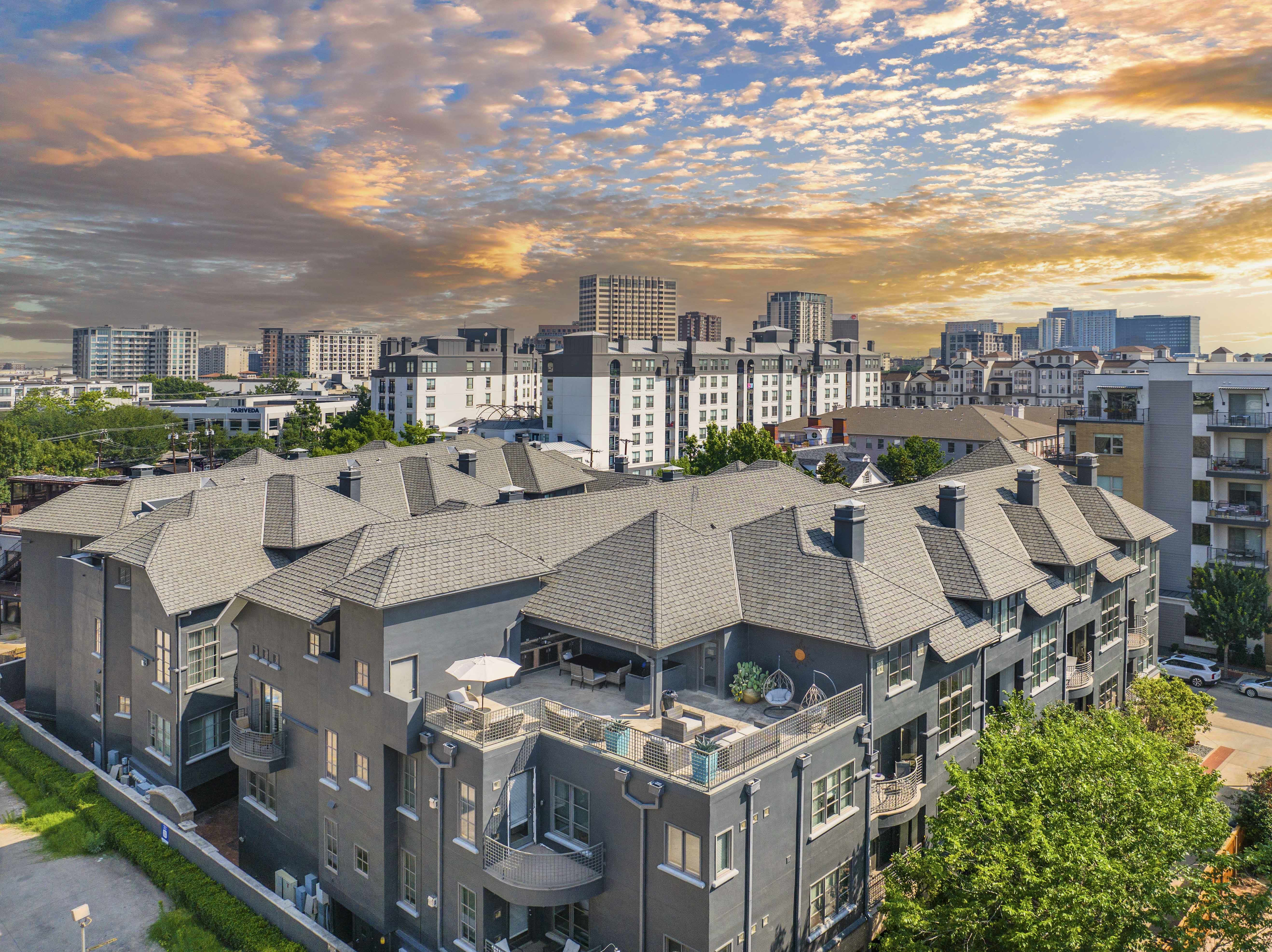 an aerial view of an apartment building with a city in the background