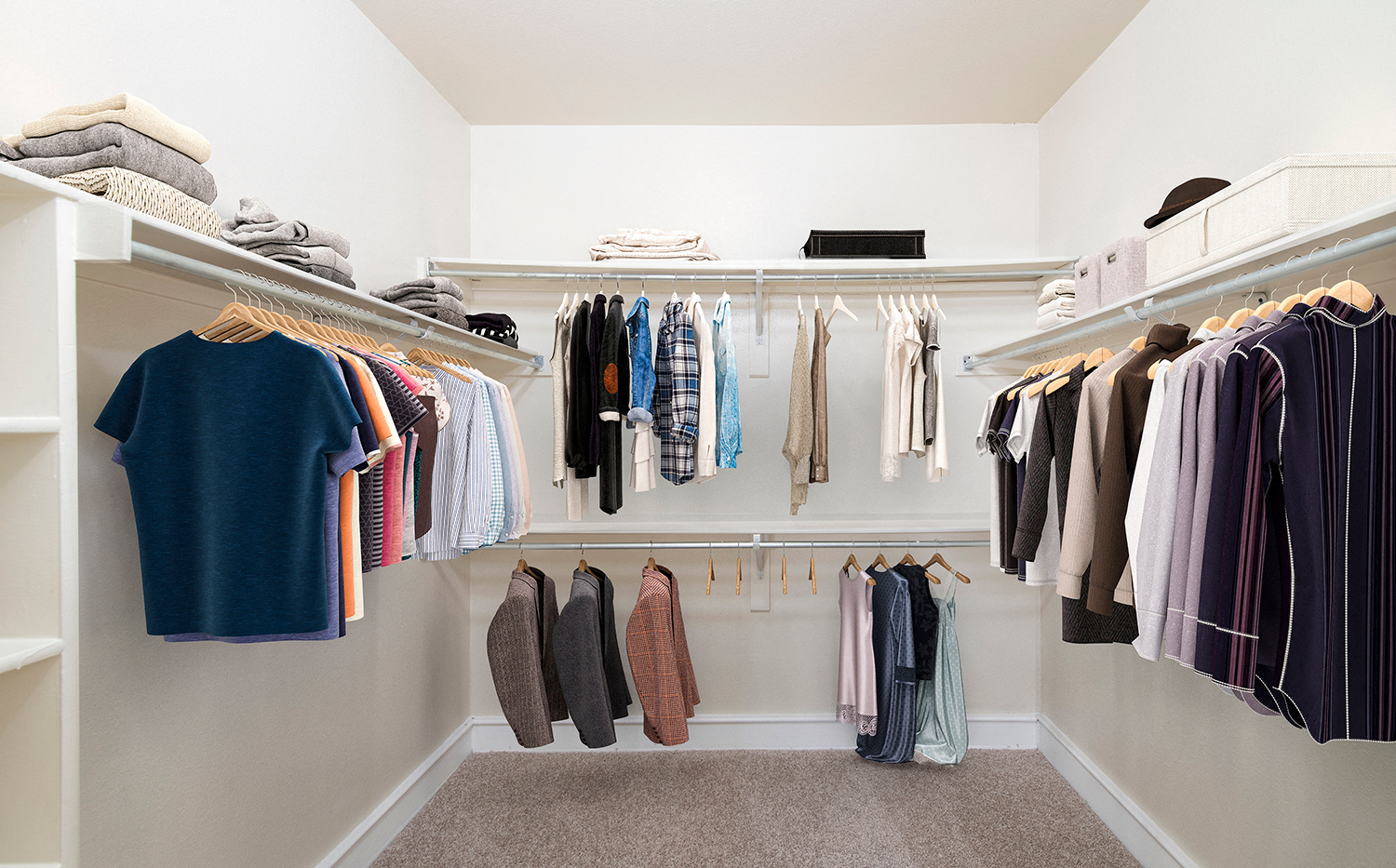 a walk in closet with a rack of clothes and a closet organizer