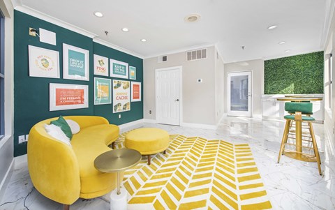 a living room with a yellow couch and a green wall