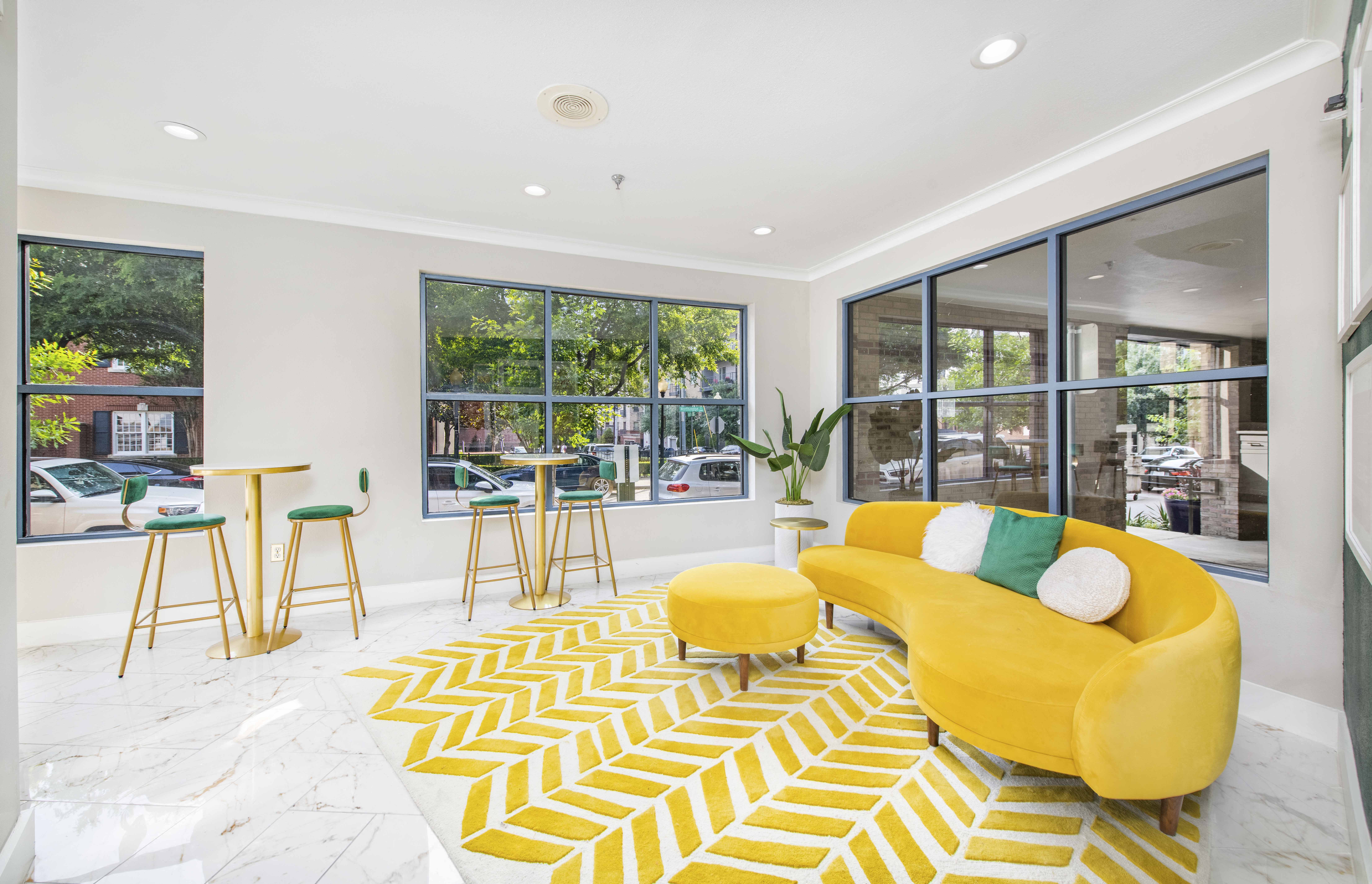 a living room with a yellow couch and a yellow and white rug