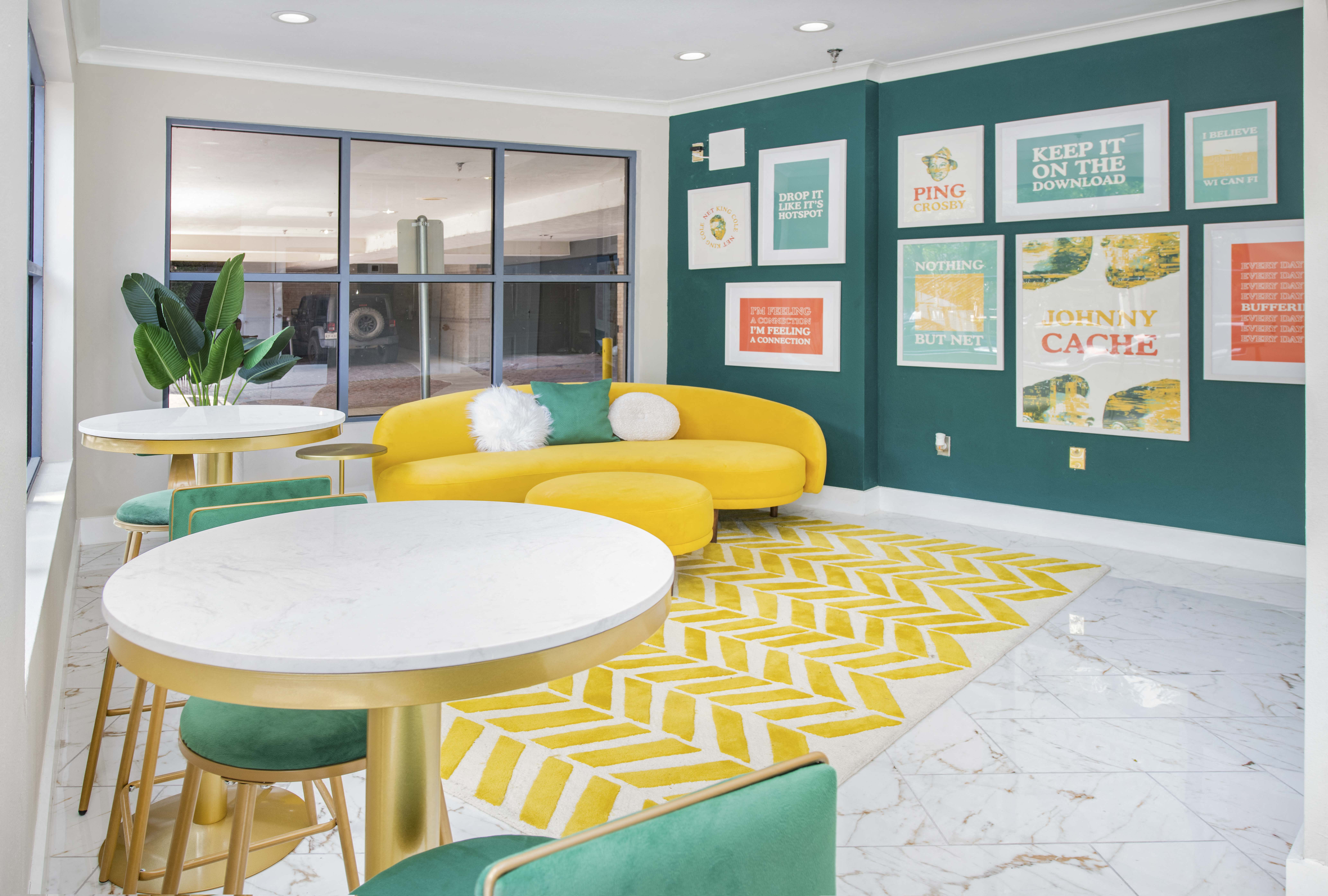 a living room with a yellow couch and a table and chairs