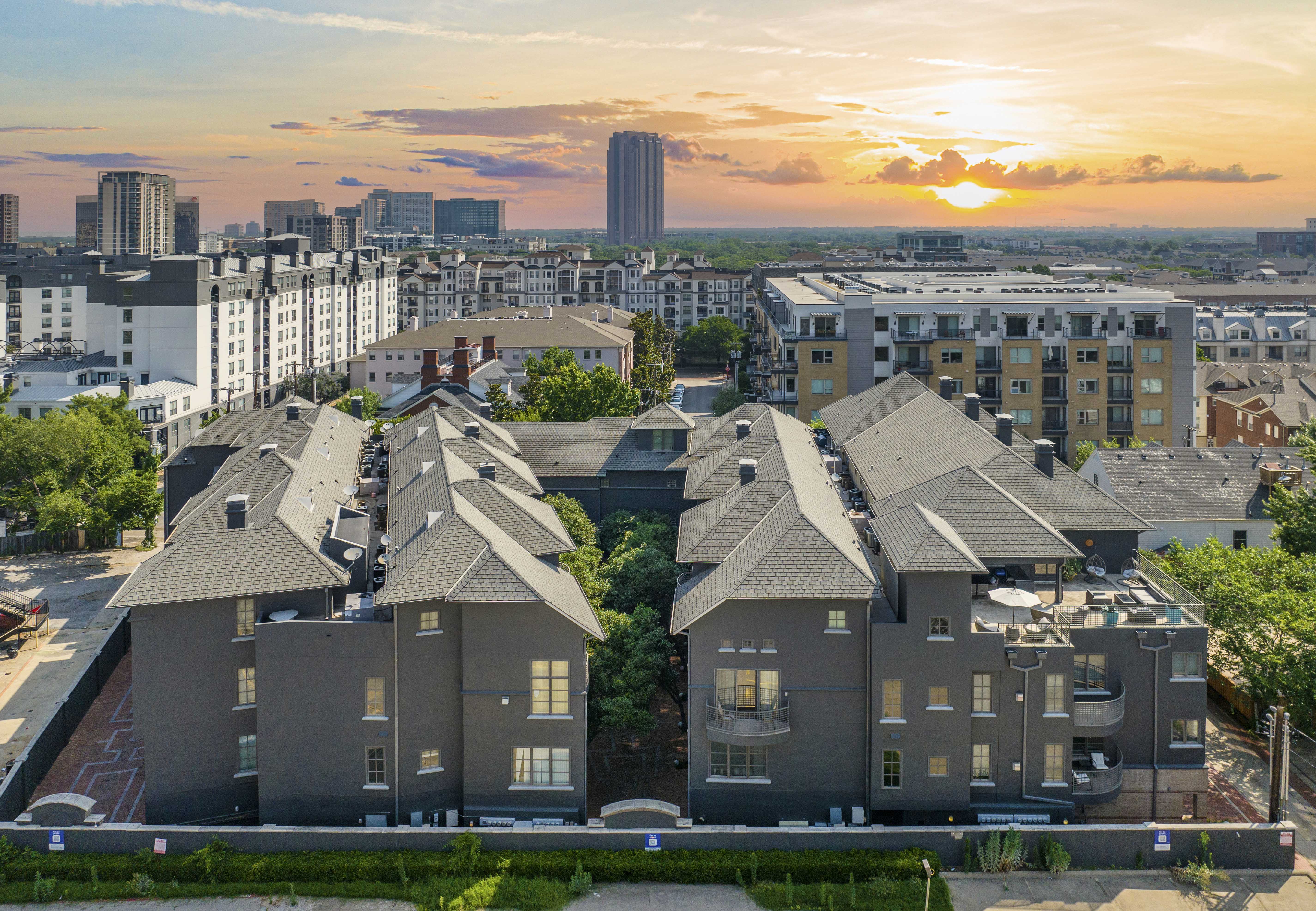 an aerial view of rooftops of buildings in a city at sunset
