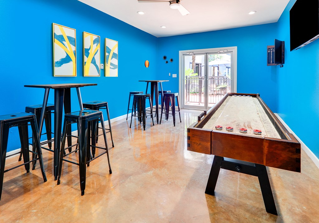 a game room with a pool table and bar