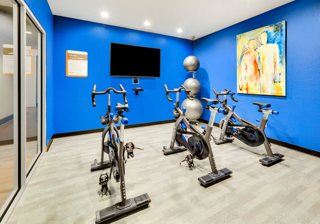 a group of exercise bikes in a room with a tv