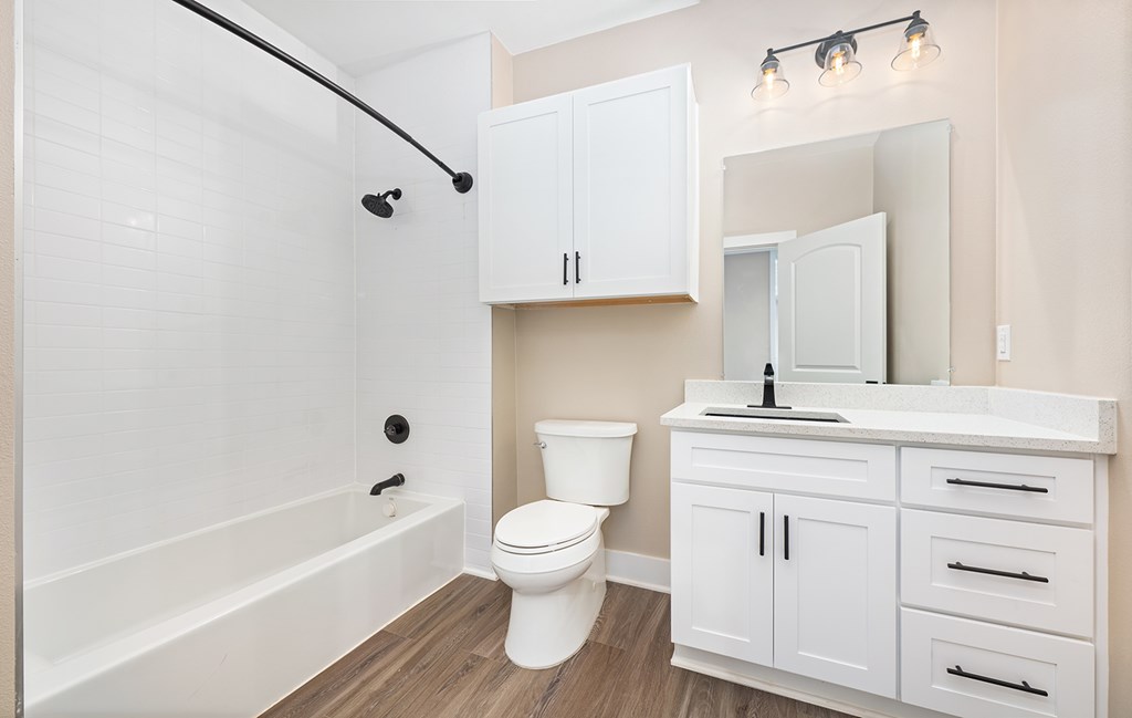 A white bathroom with a toilet, sink, and bathtub.
