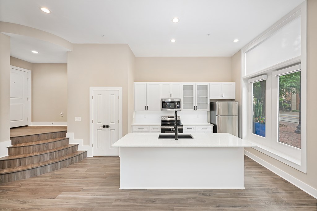 A modern kitchen with a white island and stainless steel appliances.