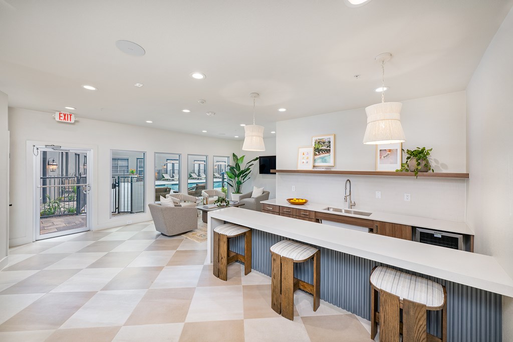 A kitchen with a checkered floor and a bar area.